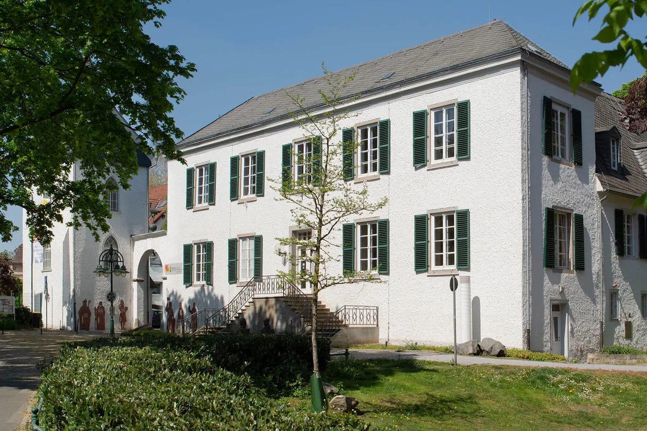 Das ehemalige Herrenhaus der Familie von Brabeck, ein weißes Gebäude mit grünen Fensterläden und einer Steintreppe.