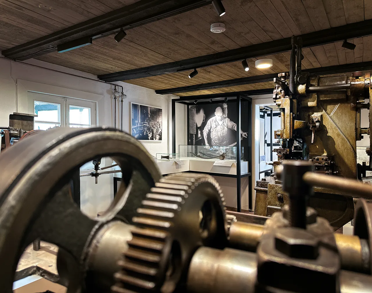Nahaufnahme von großen Metallzahnrädern und industriellen Maschinen in der Ausstellung des Nadelmuseums.