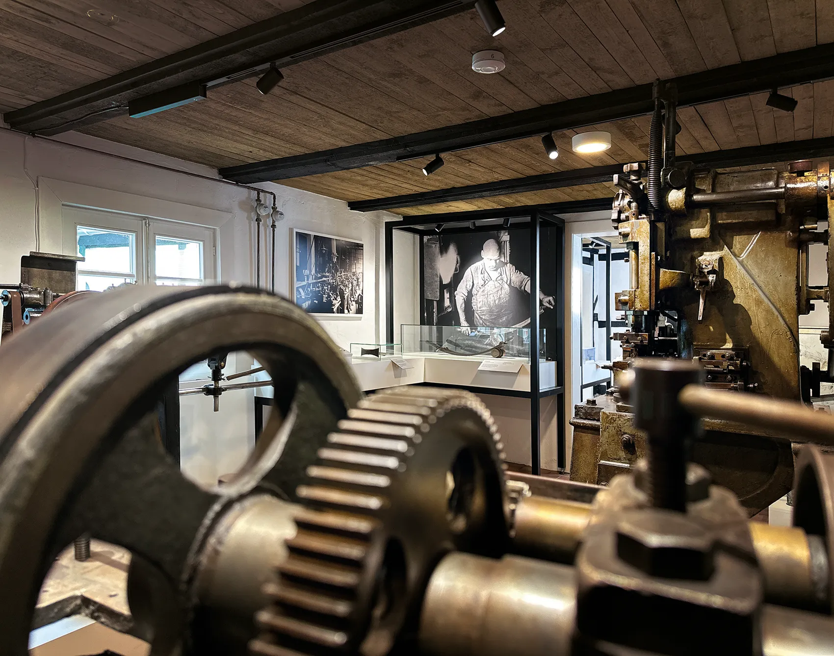 Nahaufnahme von großen Metallzahnrädern und industriellen Maschinen in der Ausstellung des Nadelmuseums.