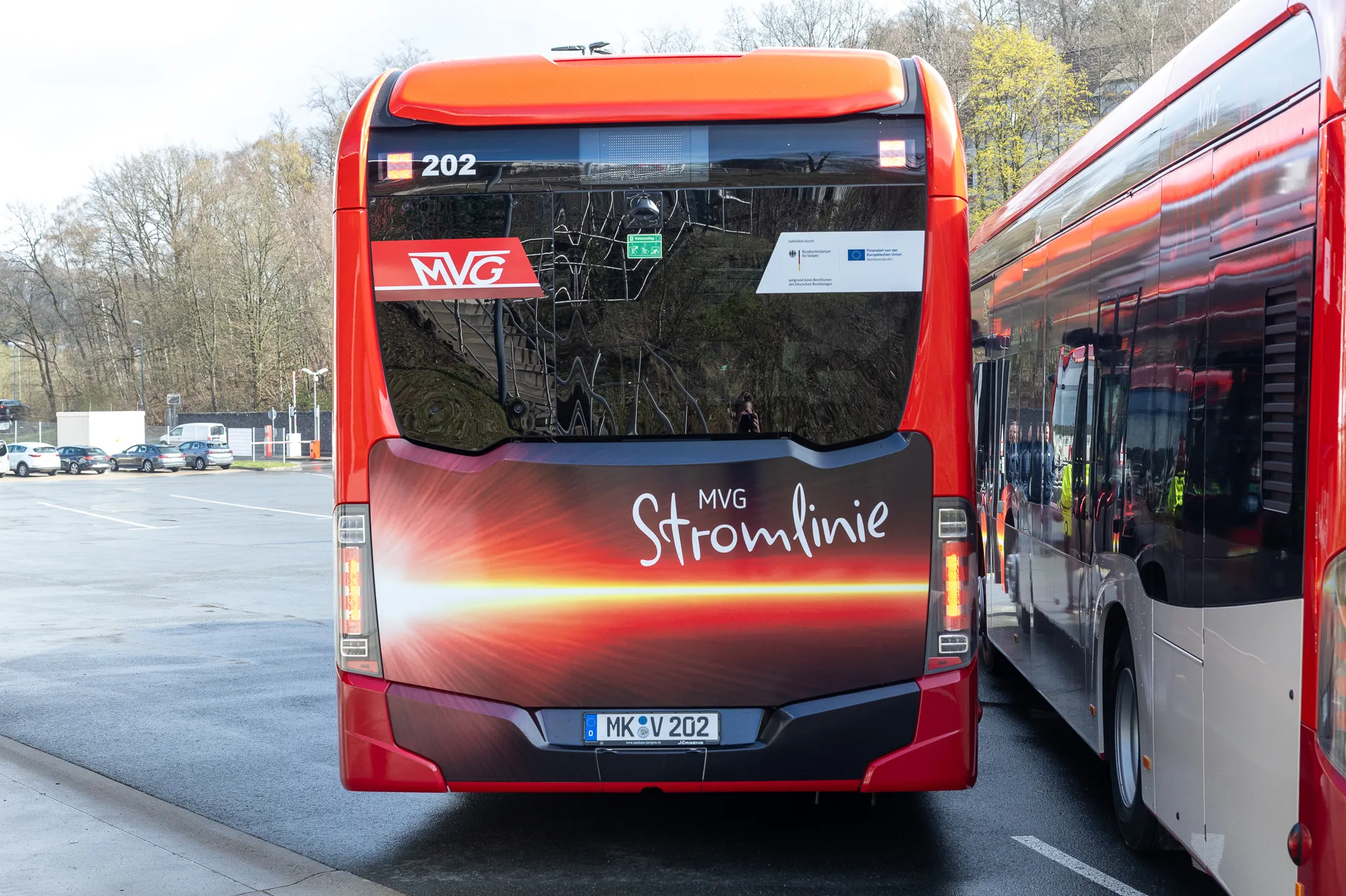 Roter Elektrobus der MVG mit der Aufschrift „Stromlinie“ und dem Liniennummernschild „202“ steht auf einer Straße.