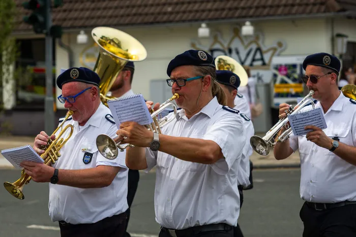 Mitglieder der Meinerzhagener Schützengilde spielen in weißen Hemden Blasinstrumente.