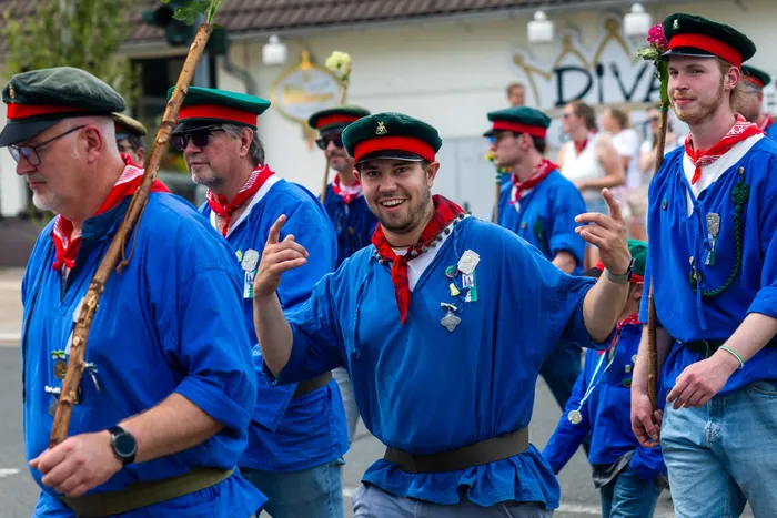 Mitglieder der Meinerzhagener Schützengilde in blauen Hemden, roten Halstüchern und grünen Kappen.