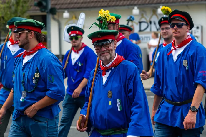 Stefan Schneider in blauer Uniform und rotem Halstuch geht in einer Parade der Meinerzhagener Schützengilde.
