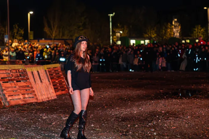 Junge Frau mit Steampunk-Brille und dunkler Kleidung steht vor einer großen Menschenmenge bei einem Osterfeuer in Lüdenscheid.