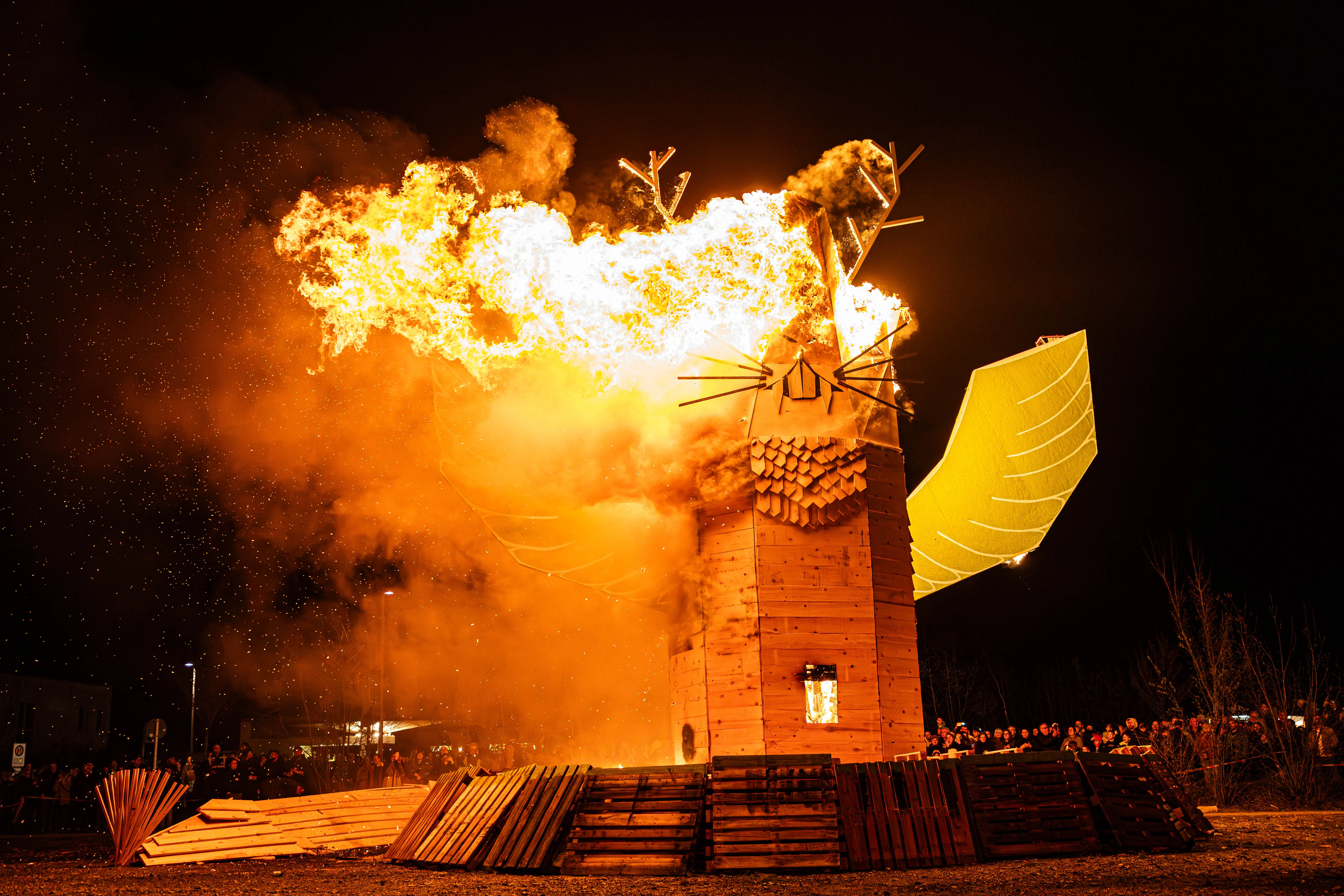 Großer, brennender Holzsteg in Form eines Fuchses mit Flügeln, umgeben von Flammen und Rauch bei einer Osterfeuer-Veranstaltung in Lüdenscheid.