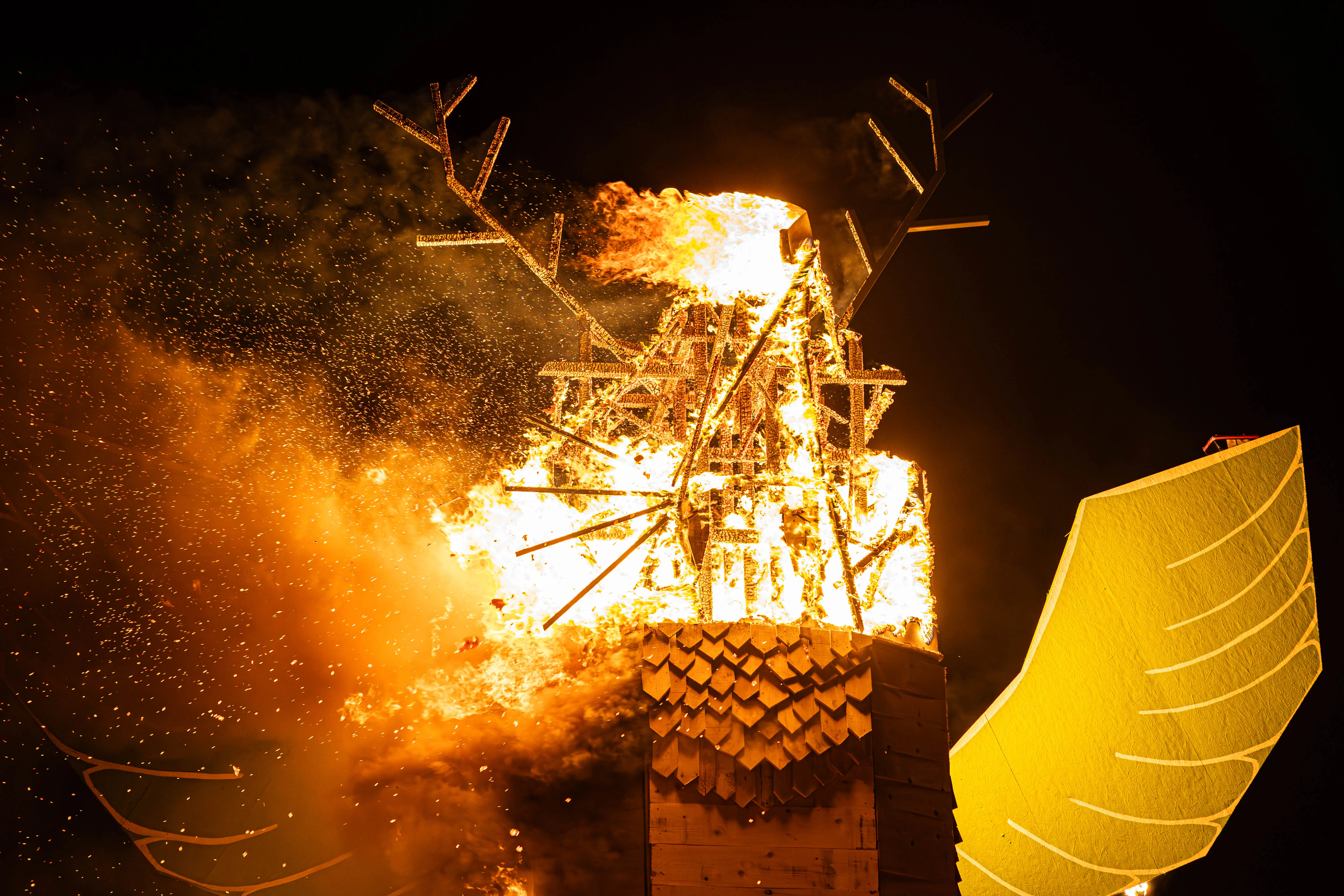 Großes Osterfeuer in Lüdenscheid brennt hell in der Nacht, Funken fliegen umher und eine große Holzkonstruktion ist von Flammen umgeben.