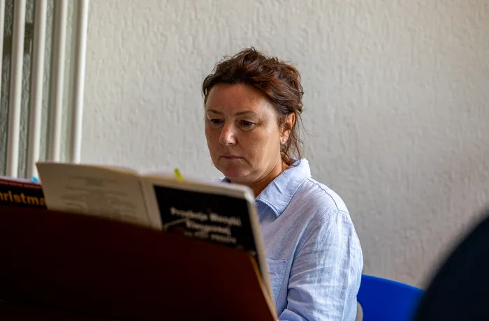 Eine Frau blickt konzentriert in ein aufgeschlagenes Buch oder Skript.