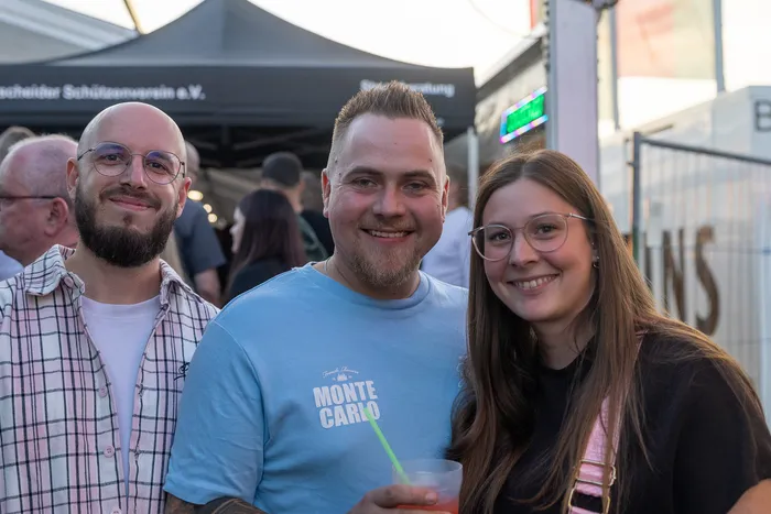 Drei lächelnde junge Menschen posieren bei der zehnten Q-Stall-Party in Schalksmühle.