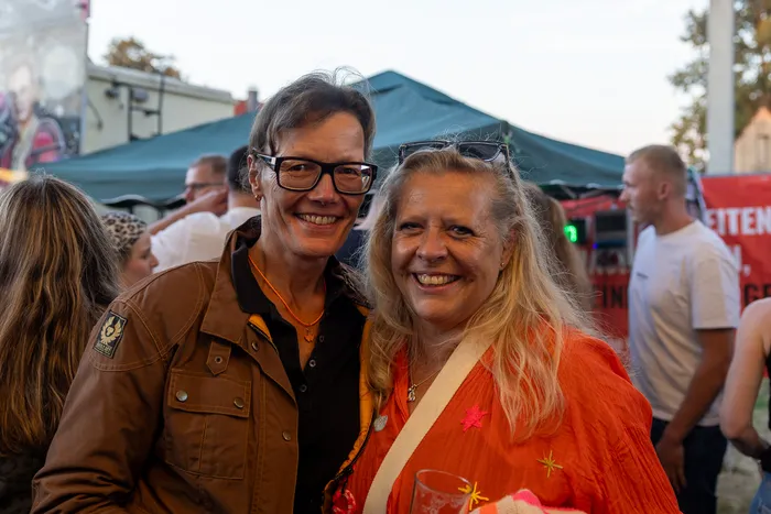 Zwei lächelnde Frauen stehen eng beieinander bei der Q-Stall-Party in Schalksmühle.