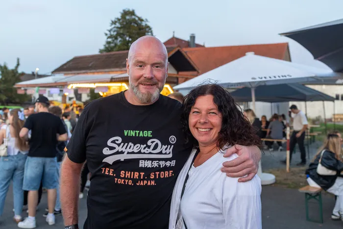 Ein lächelnder Mann und eine Frau posieren bei der Q-Stall-Party in Schalksmühle.