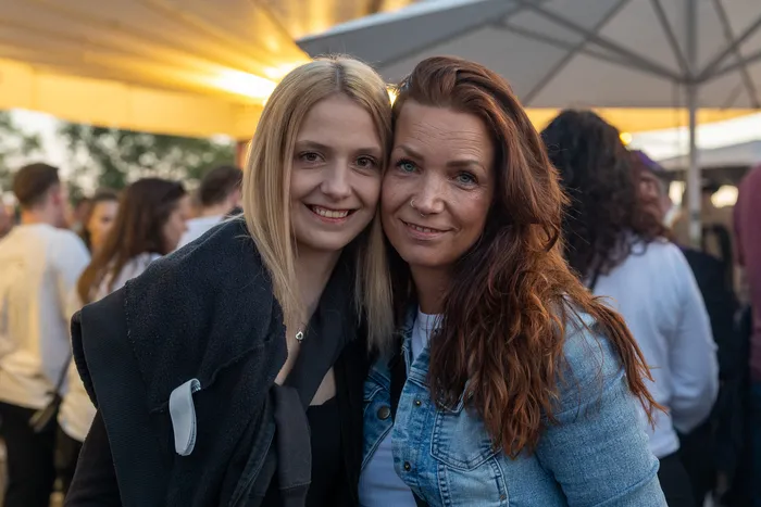 Zwei lächelnde Frauen mit blonden und rötlichen Haaren posieren eng beieinander bei der Q-Stall-Party in Schalksmühle.