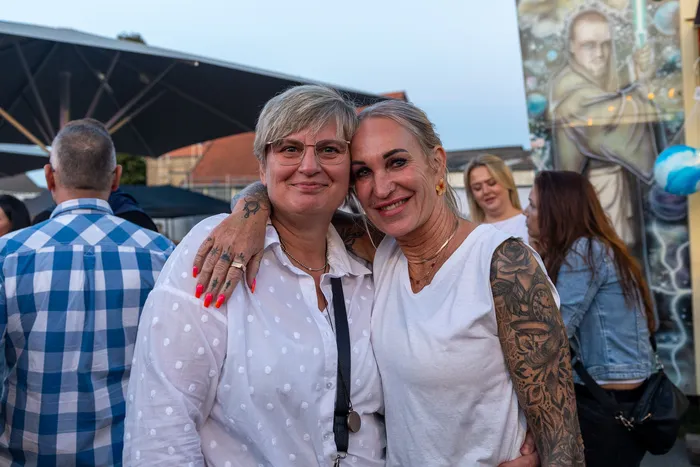 Zwei lächelnde Frauen umarmen sich bei der zehnten Q-Stall-Party in Schalksmühle.