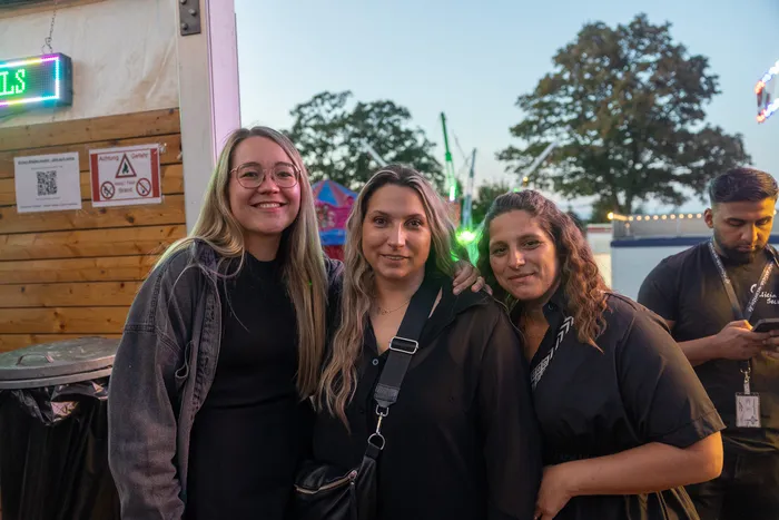 Drei lächelnde junge Frauen posieren bei der Q-Stall-Party in Schalksmühle.