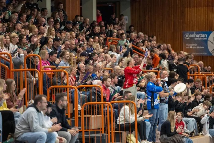 Zuschauer in einer Sporthalle klatschen und jubeln bei einem Spiel der SGSH Dragons.