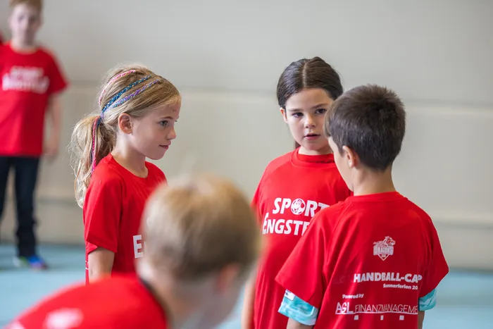 Kinder in roten T-Shirts stehen im Kreis während des SGSH Sommercamps 2026.