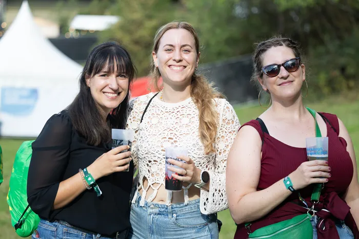 Drei lächelnde Frauen halten Plastikbecher mit Getränken bei einem Outdoor-Event von Bautz 2026.