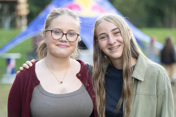 Zwei lächelnde junge Frauen vor einem blauen Zelt auf der Bautz 2026 Turntable Stage.