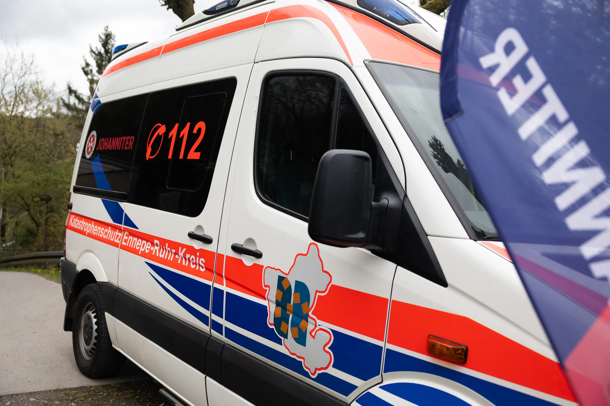 Weißer Rettungswagen mit rotem Kreuz und der Notrufnummer 112, beschriftet mit „Katastrophenschutz Ennepe-Ruhr-Kreis“.