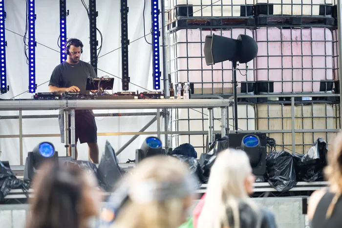 DJ Disco Danny steht an seinem Mischpult auf der Turntable Stage beim Bautz 2026 vor blauen LED-Leisten und großen Industriebehältern.