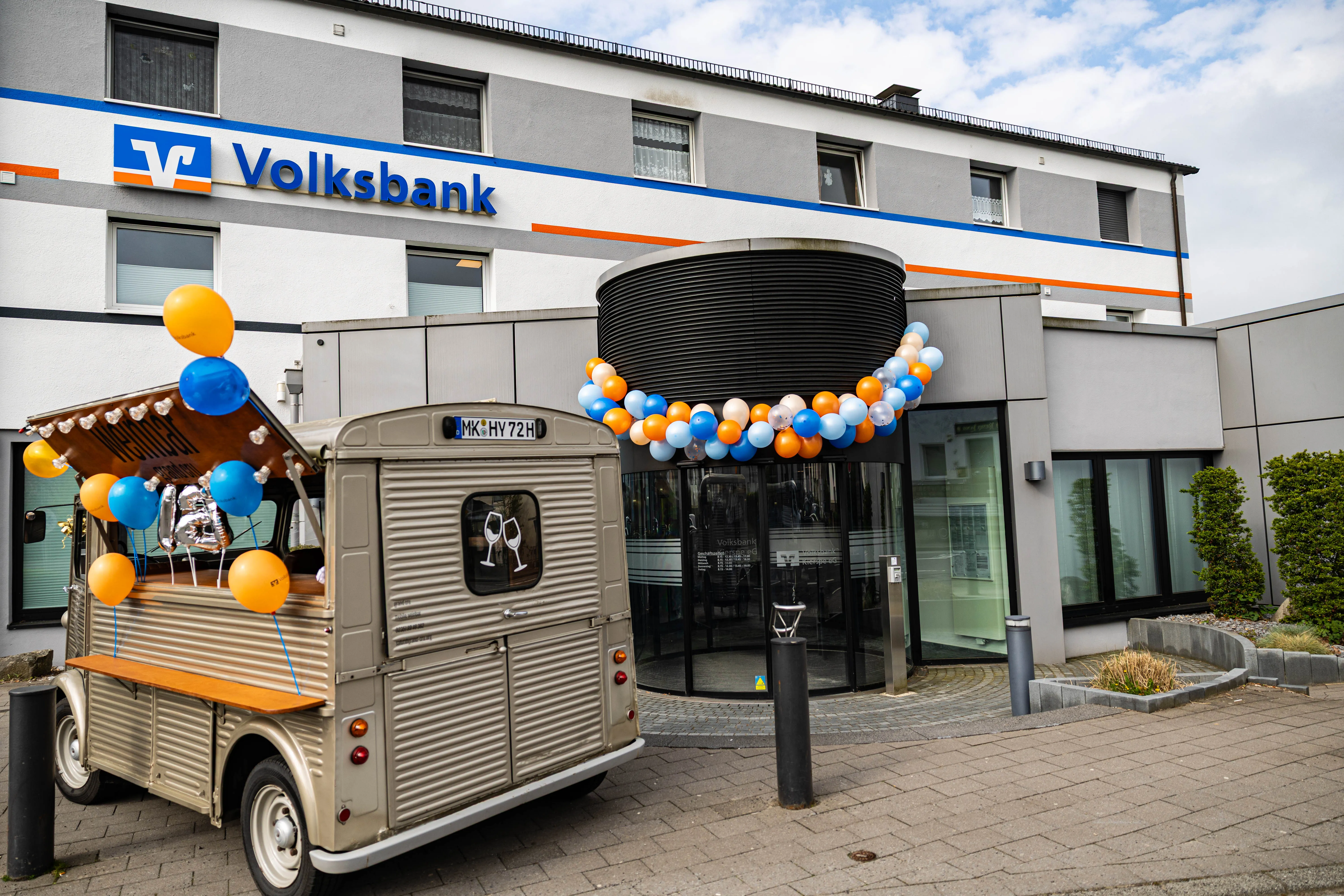 Ein Foodtruck mit Luftballons steht vor dem Gebäude der Volksbank Kierspe anlässlich des 125-jährigen Jubiläums.