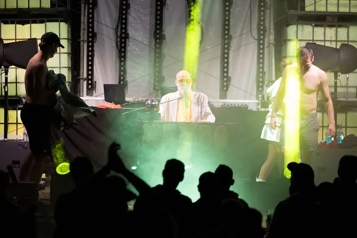 Mambo Kurt in einem weißen Anzug steht hinter einem DJ-Pult auf der Turntable Stage beim Bautz 2026 Festival unter grünem Bühnenlicht.