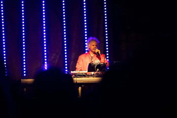 Jan-Christian Zeller performt an einem Turntable-Pult vor vertikalen blauen LED-Lichtstreifen.