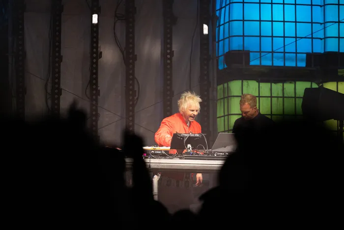 Jan-Christian Zeller mit blonden, stacheligen Haaren und roter Jacke bedient an der Turntable Stage Mischpulte und Laptops.