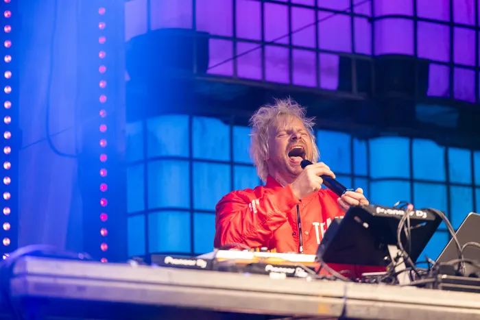 Jan-Christian Zeller singt in ein Mikrofon hinter einem DJ-Pult auf der Turntable Stage beim Bautz 2026.