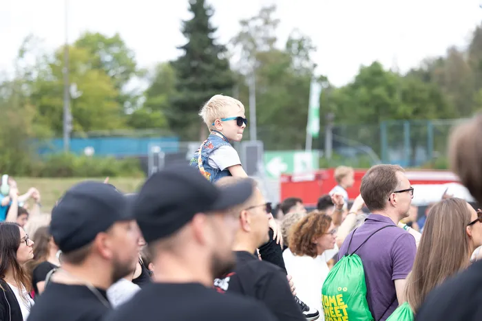 Ein kleiner Junge mit blonden Haaren und Sonnenbrille wird in einer Menschenmenge bei der Bautz 2026 Main Stage hochgehalten.