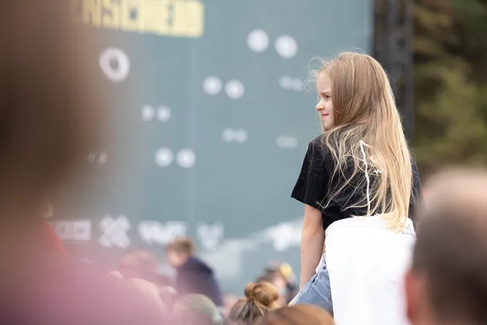 Ein Mädchen mit langen blonden Haaren blickt seitlich in Richtung der Bühne bei Bautz 2026.
