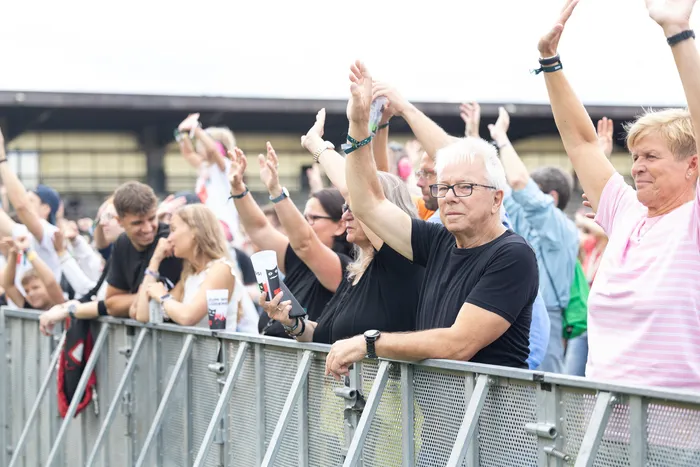 Zuschauer mit erhobenen Händen stehen hinter einer Metallabsperrung vor der Main Stage beim Bautz 2026 Festival.