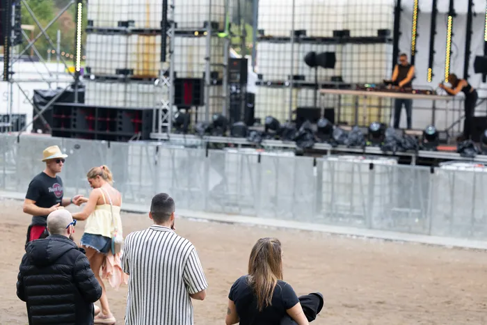 Ein DJ performt an der Turntable Stage beim Bautz 2026 Festival vor einer Kulisse aus großen Fässern, während Zuschauer im Vordergrund zusehen.