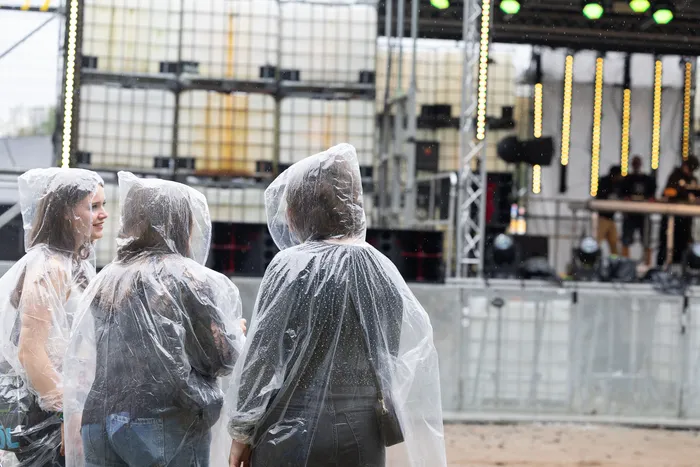 Drei Personen in durchsichtigen Regenponchos blicken auf die Turntable Stage beim Bautz 2026.