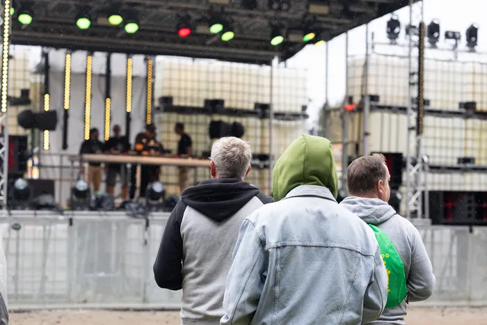 Drei Personen von hinten betrachtet, die auf die beleuchtete Turntable Stage bei Bautz 2026 schauen.