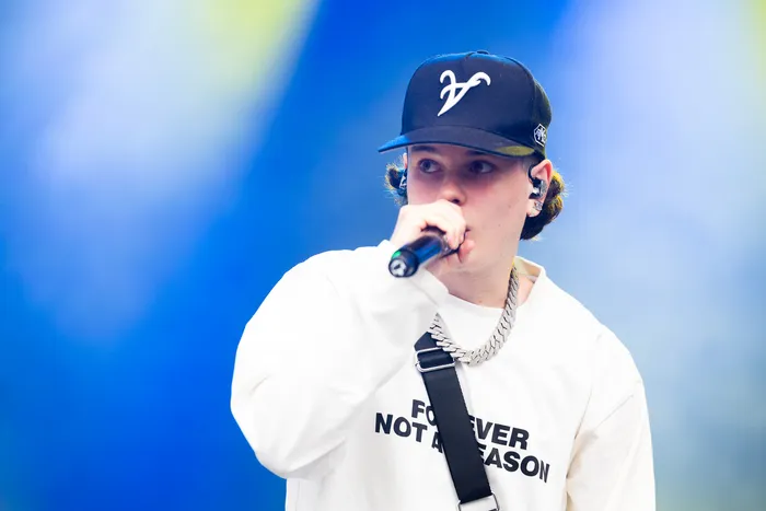 Benno singt auf der Main Stage des Bautz 2026 Festivals in ein Mikrofon. Er trägt eine schwarze Kappe und ein weißes Shirt mit der Aufschrift „FOREVER NOT A REASON“.