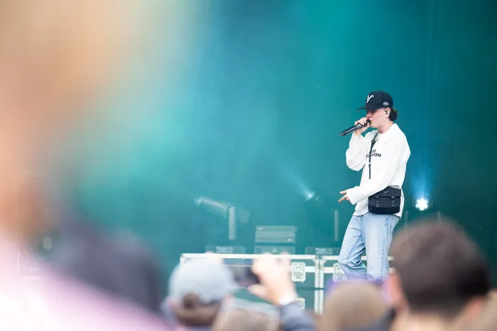 Benno singt auf der Main Stage beim Bautz 2026 in ein Mikrofon vor einem türkisfarbenen Hintergrund.