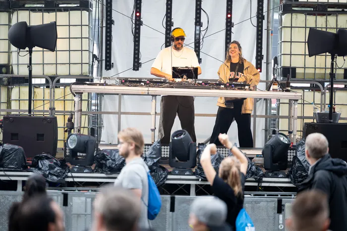 Ante Perry steht an einem DJ-Pult auf der Turntable Stage vor einem Publikum.