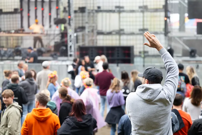 Ein Mann mit erhobenem Arm steht in einer Menschenmenge vor der Turntable Stage beim Bautz 2026 Festival.
