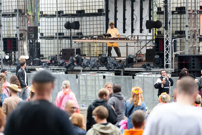 DJ Ante Perry steht an seinem Mischpult auf einer Bühne aus weißen Industriecontainern vor einer Menschenmenge beim Bautz 2026 Festival.