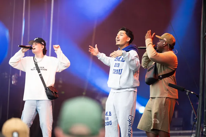 Drei junge Männer performen mit Mikrofonen auf der Main Stage beim Bautz 2026 unter blauem und rotem Bühnenlicht.