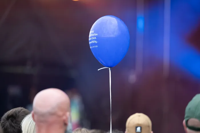 Ein blauer Luftballon mit weißer Aufschrift schwebt über einer Menschenmenge bei der Bautz 2026 Main Stage.