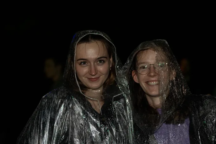Zwei lächelnde Frauen in durchsichtigen Regenponchos bei Nacht auf dem Bautz 2026 Festival.