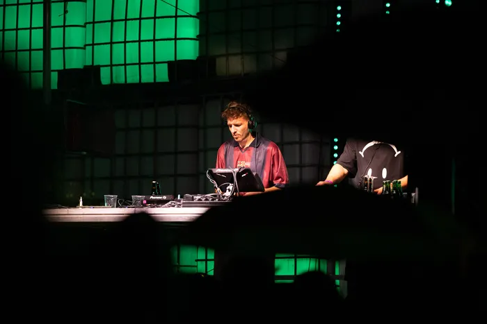 Ein DJ bedient ein Mischpult auf der Turntable Stage beim Bautz 2026 vor grün beleuchteten Paneelen.