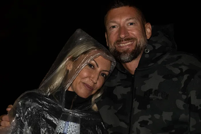 Ein lächelndes Paar bei der Bautz 2026; die Frau trägt einen durchsichtigen Regenponcho, der Mann einen Camouflage-Hoodie.