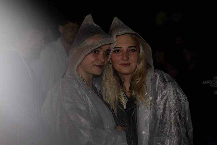Zwei junge Frauen in transparenten Regenmänteln mit Kapuzen lächeln beim Bautz 2026.