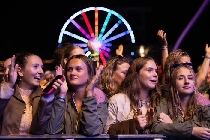 Junge Menschen applaudieren bei der Mainstage des Bautz 2026 Festivals vor einem hell erleuchteten Riesenrad bei Nacht.