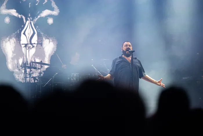 Ein Sänger mit Bart singt mit ausgebreiteten Armen auf der Mainstage des Bautz 2026 vor einer großen, abstrakten weißen Projektion.