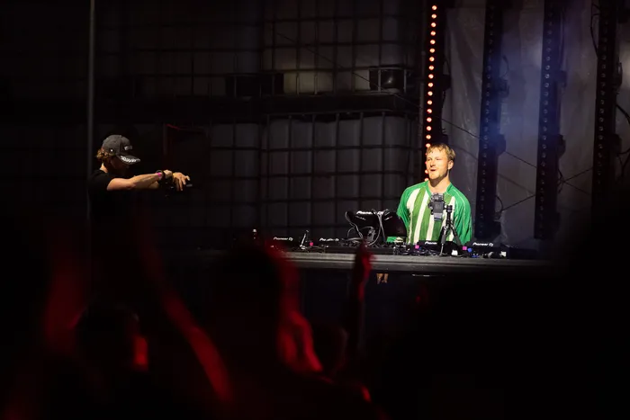 DJ Paracek in einem grün gestreiften Shirt bedient Mischpulte auf der Turntable Stage.