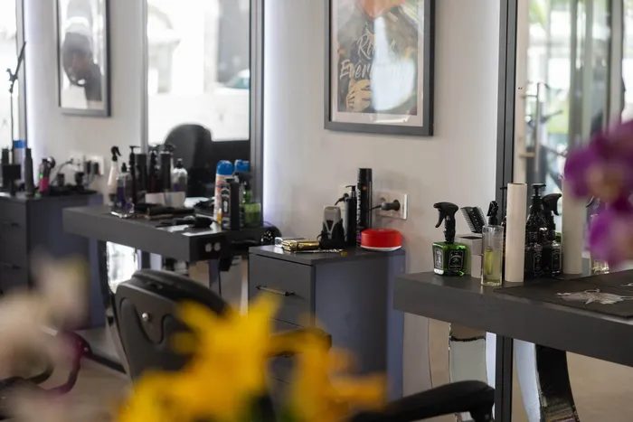 Innenansicht eines Friseursalons mit Styling-Stationen, Spiegeln und verschiedenen Haarpflegeprodukten.