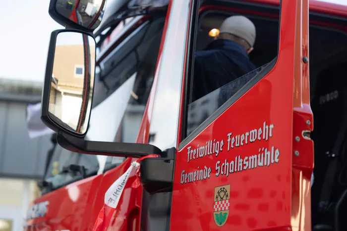 Rotes Feuerwehrfahrzeug der Freiwilligen Feuerwehr Schalksmühle mit Fokus auf dem Seitenspiegel.
